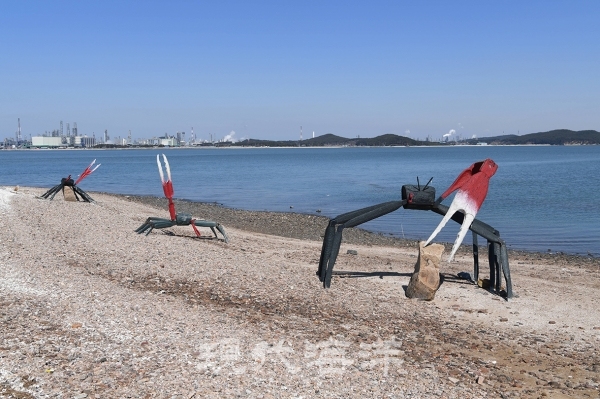벌천포에 설치된 장경희작가의 ‘뭍으로 올라온 황발이’, 대로 보이는 대산공단