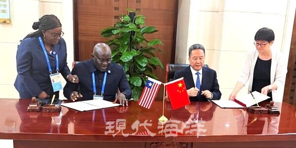 네토 자르자르 리게 씨(Mr. Neto Zarzar Lighe Sr) 라이베리아 해사청장과 리 샤오평 씨(Mr. Li Xiaopeng) 중국 교통부장관이 협약서에 서명하고 있다(사진=라이베리아 기국)