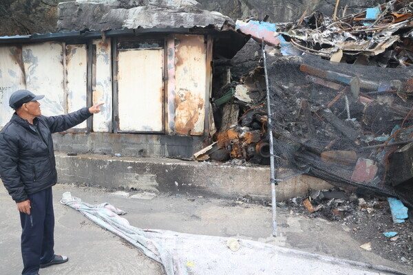 노물항 전소된 어선잔해를 가르키는 하중광 노물리어촌계장