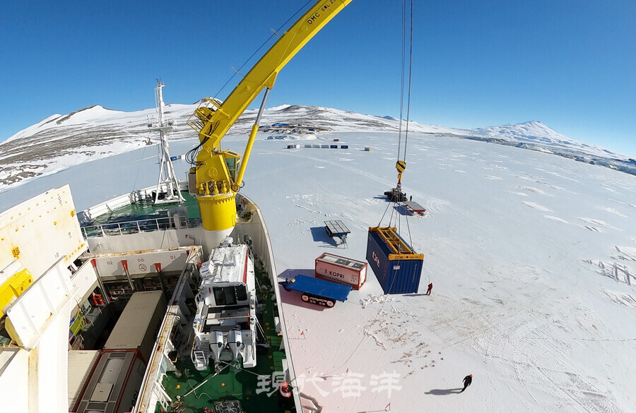 아라온호의 크레인으로 컨테이너를 얼음판 위에 내려놓고 있다.