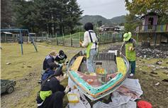 학교의 상징물인 조각배를 초벌 칠하고 있다.